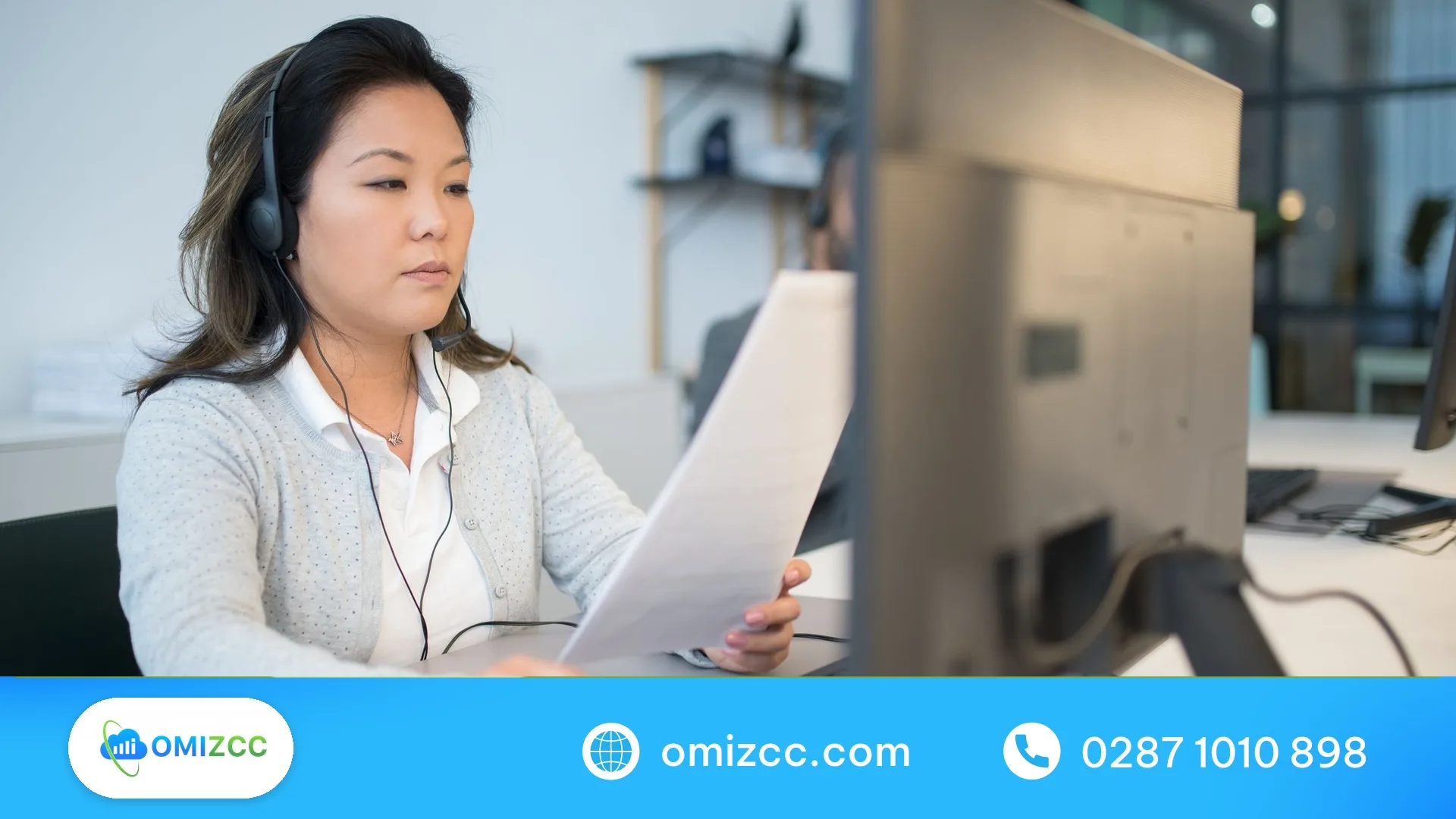 Nhân viên chăm sóc khách hàng đeo tai nghe xem hồ sơ yêu cầu của khách